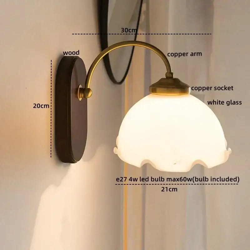 Antique brass floral frosted glass led wall light with dark wood backplate and scalloped white shade for bedroom sconce