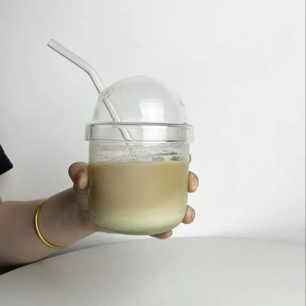Clear glass bobo cup with ribbed lid and curved straw filled with light green beverage from decorbites clear glass set