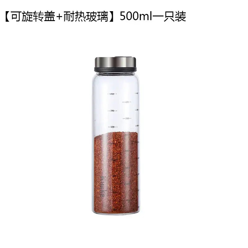 Clear glass spice shaker with rotary lid filled with red pepper flakes for salt sesame pepper storage