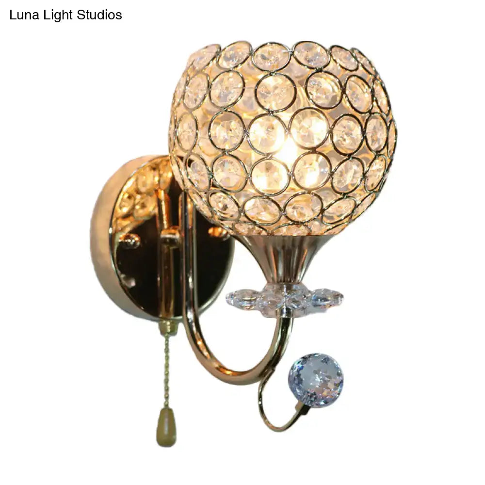 Contemporary gold wall sconce with beveled glass globe and decorative crystals for living room lighting