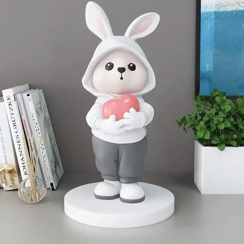 Cute white bunny figurine wearing a hoodie and holding a pink heart for home decor rabbit desk figurines