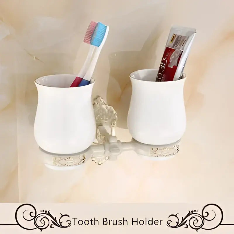 White ceramic brush holder with ornate silver aluminum base and decorative scrollwork in DecorBites bath hardware set