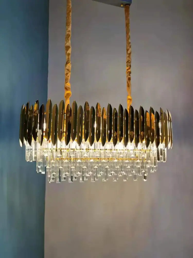Gold-toned DecorBites crystal chandelier with circular metallic blades and clear crystal droplets for modern dining rooms