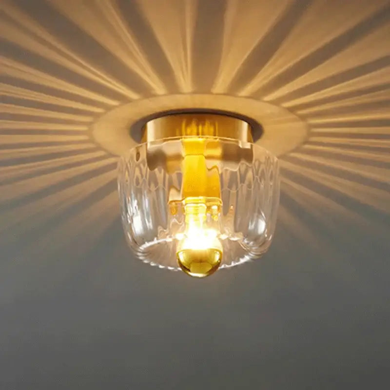 Decorbites led indoor glass ceiling light fixture with textured clear glass and gold base casting radial shadows