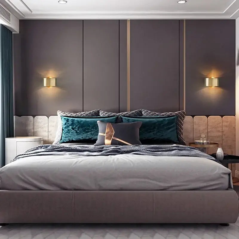 Gray upholstered bed with tufted headboard and teal velvet pillows beside decorbites led outdoor wall light