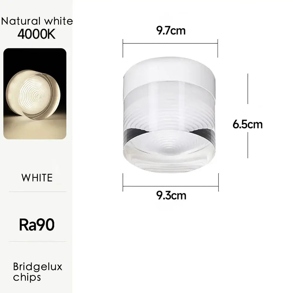 A sleek white cylindrical decorbites led surface mounted spot light with frosted glass and concentric ridges for ceiling use