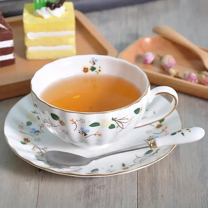A delicate white porcelain saucer set with elegant gold flower trim filled with amber tea for dining room decorbites elegant gold decor