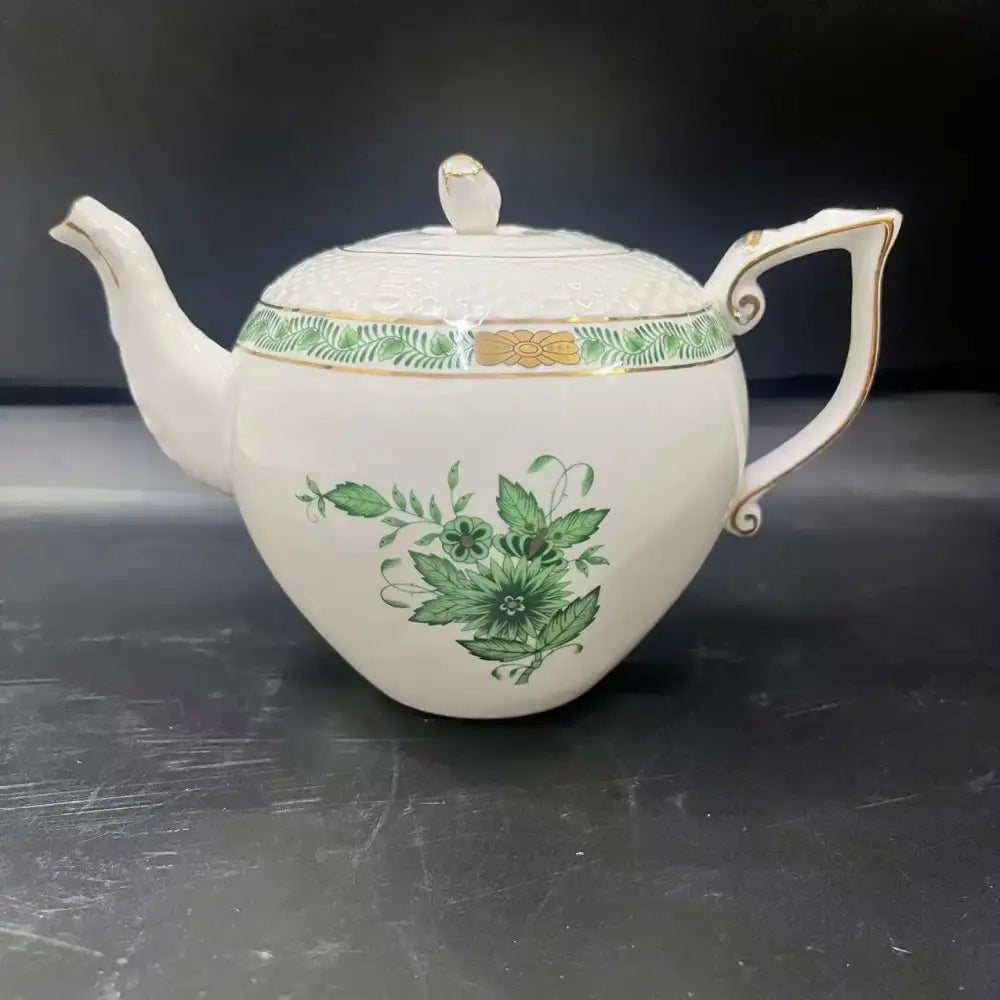 White porcelain teapot with green floral and leaf patterns and gold trim from floral white and green ceramic tea cup set
