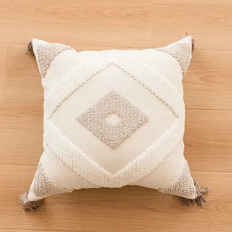 Cream-colored geometric tufted beige cushion cover with textured pattern and tassel trim for living room decorbites