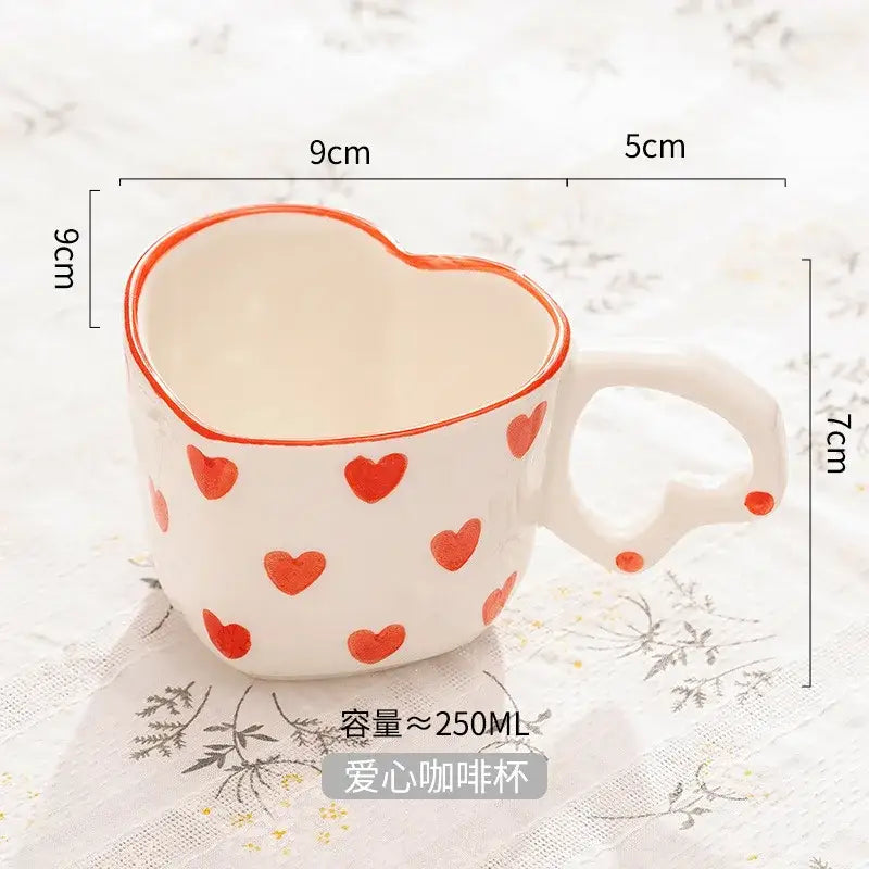 White ceramic love mug with hand painted heart handle and red heart decals paired with pink polka dot saucer set