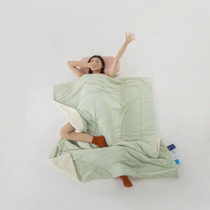 Light blue and white bedroom comforter with soft mint green quilted side and cream cream inner lining made with decorbites cooling fabric
