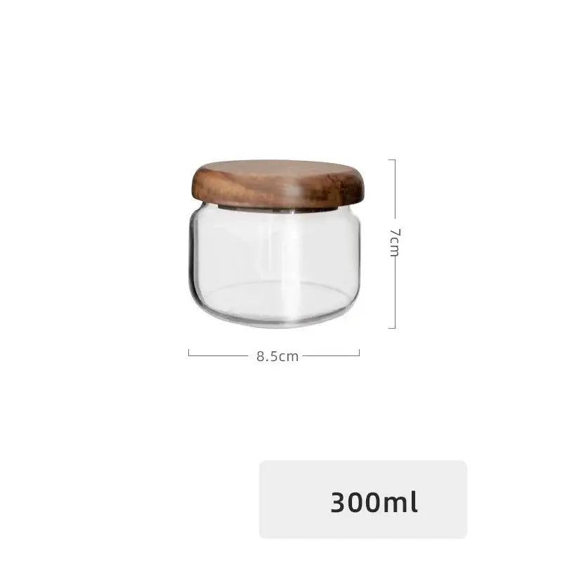 Minimalist clear glass storage jar with a smooth rounded acacia wood lid for kitchen organization