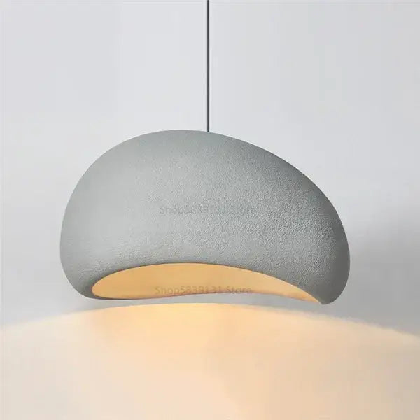 Gray concrete decorbites cobblestone pendant lights with smooth curved design and warm interior glow for dining room decor