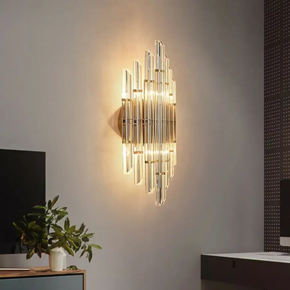 Minimalist gold k9 crystal wall sconce light featuring vertical glass rods illuminated by warm light for living room use