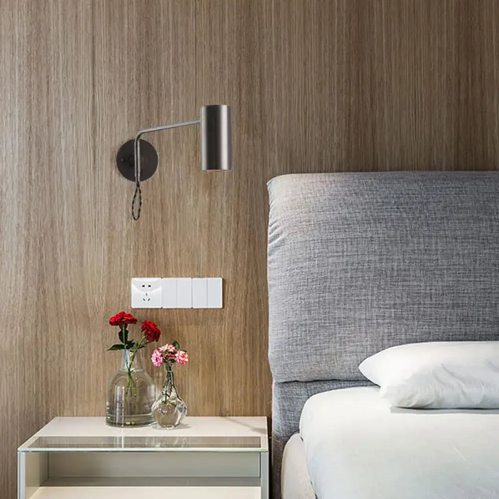 Minimalist gold metal wall lamp with a matte black bedside spotlight and sleek cylindrical bulb base for bedroom use