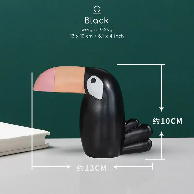 Minimalist turquoise and gold decorbites bird figurine office phone holder featuring a black toucan with a pink and peach beak