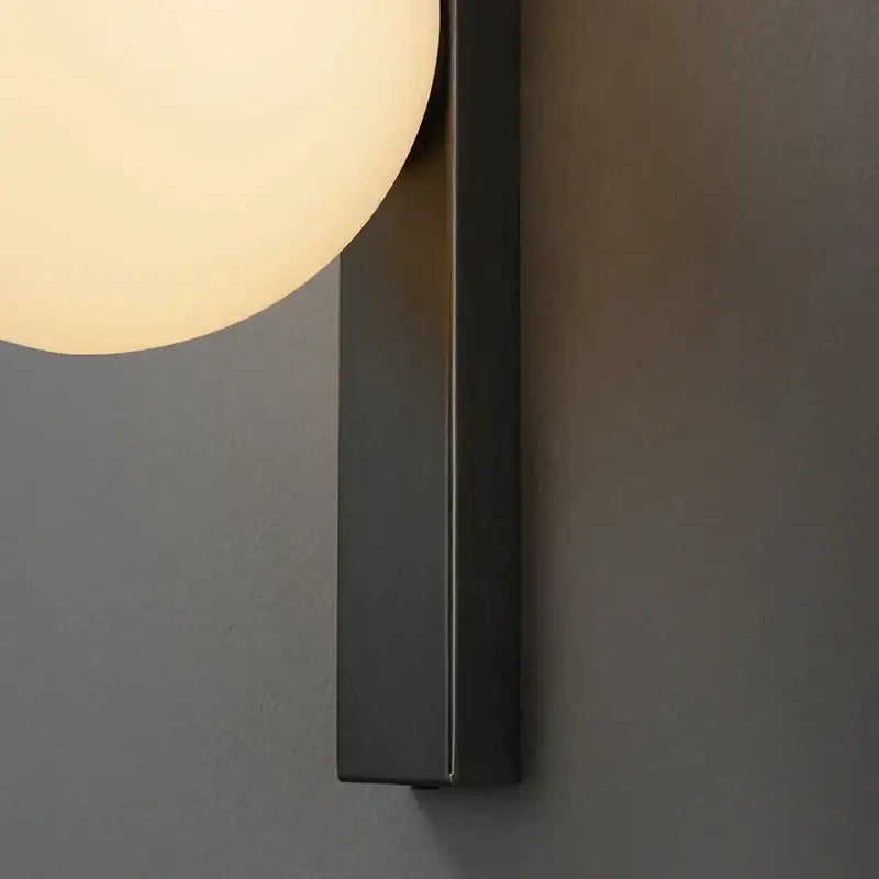 Modern black copper globe led wall sconce with matte black finish and warm frosted glass globe for bedroom lighting