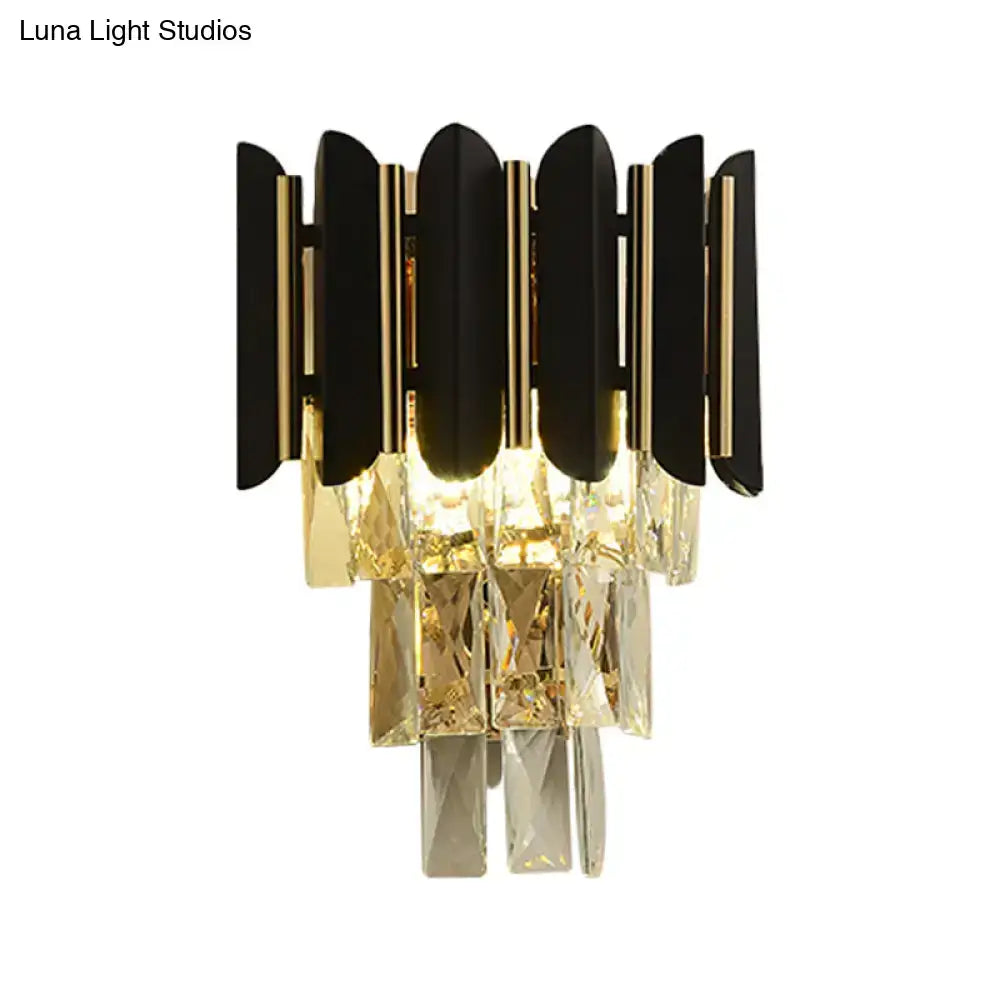 Modern black and gold wall sconce with black finish and cascading clear faceted crystals for bedroom use