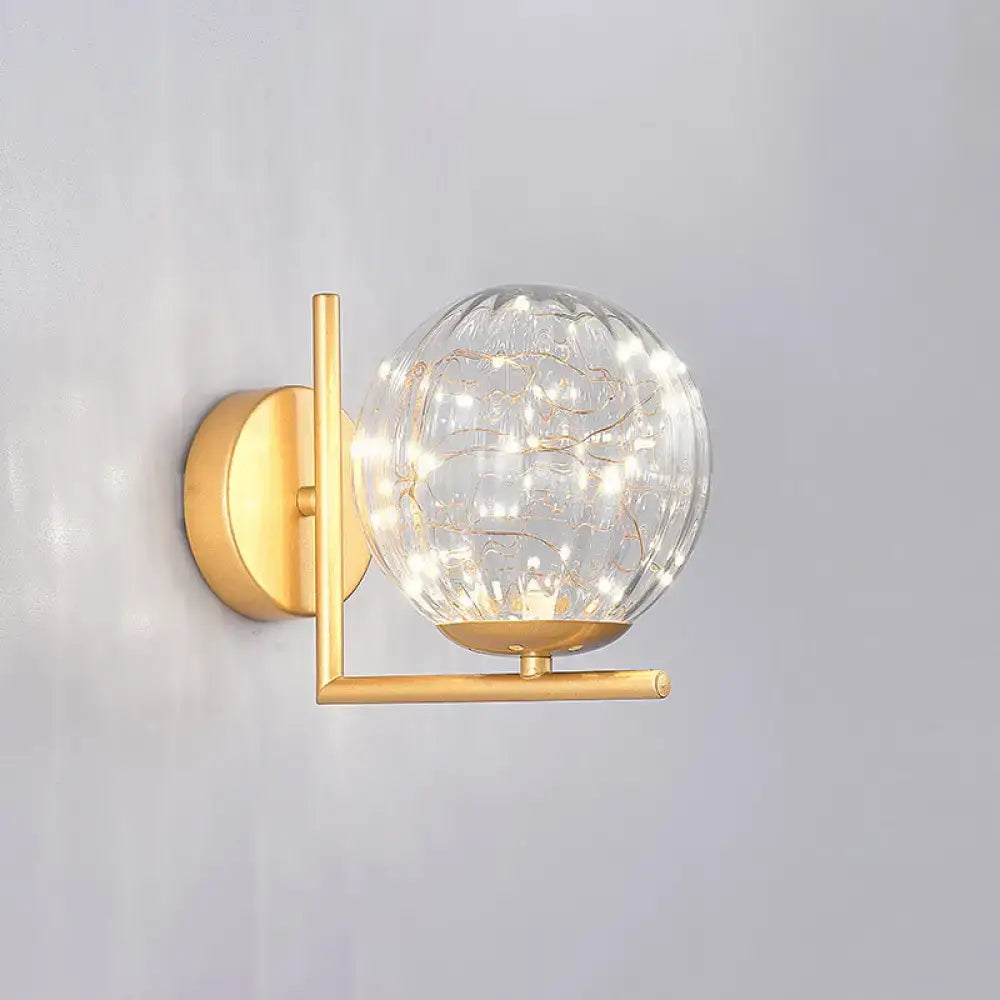 Gold-toned mini globe wall sconce with textured glass globe and delicate string lights for fixture height versatility