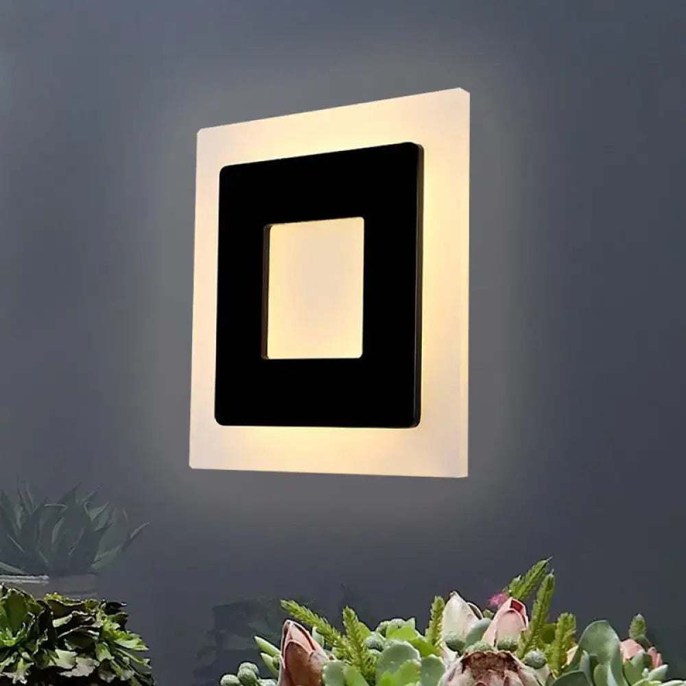 Modern black square sconce light with sleek frame and glowing panel emitting warm light ideal for bedroom ambiance
