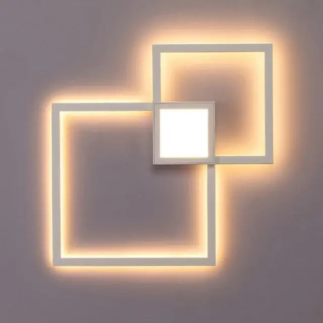 Modern black and white square led wall sconce with overlapping geometric design and warm ambient bedroom lighting