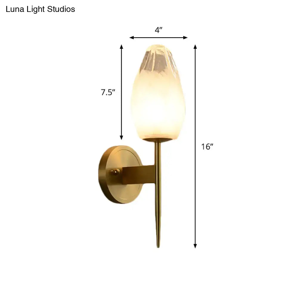 Modern brass and clear glass wall lamp bedroom sconce with a warm frosted glass shade and brass-finished metal base and stem