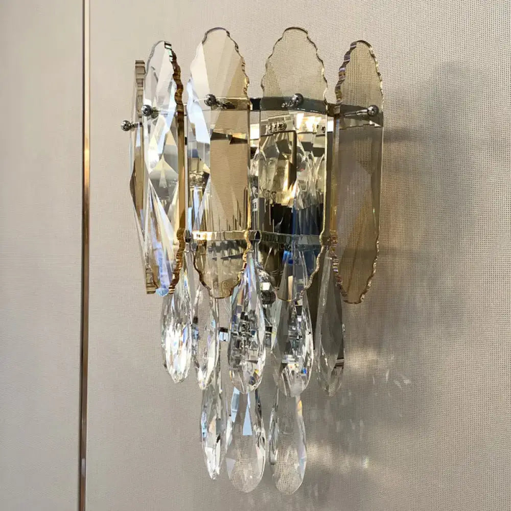 Modern champagne smoke gray crystal wall sconce with faceted leaves and teardrop pendants on polished brass hardware