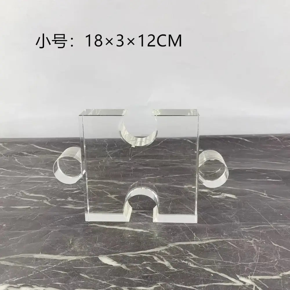Modern clear acrylic crystal geometric puzzle bookends featuring clear acrylic puzzle piece shape with three circular cutouts