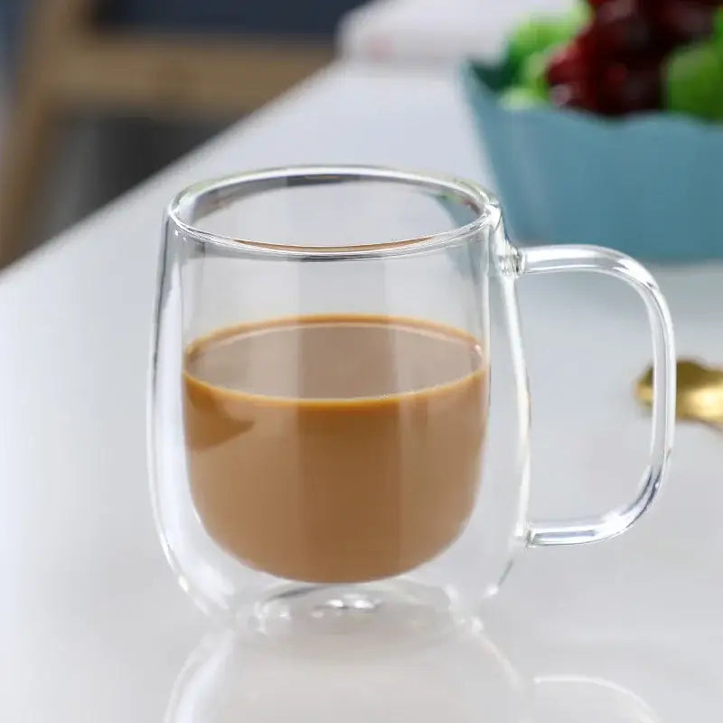Modern double walled glass coffee mug by decorbites filled with brown liquid showcasing a clear glass coffee mug design