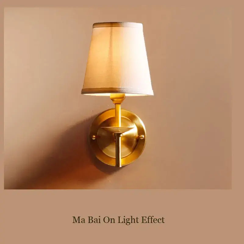 A warm-toned brass wall lamp with a tapered cream fabric shade perfect for modern bedroom decorbites copper wall lamp