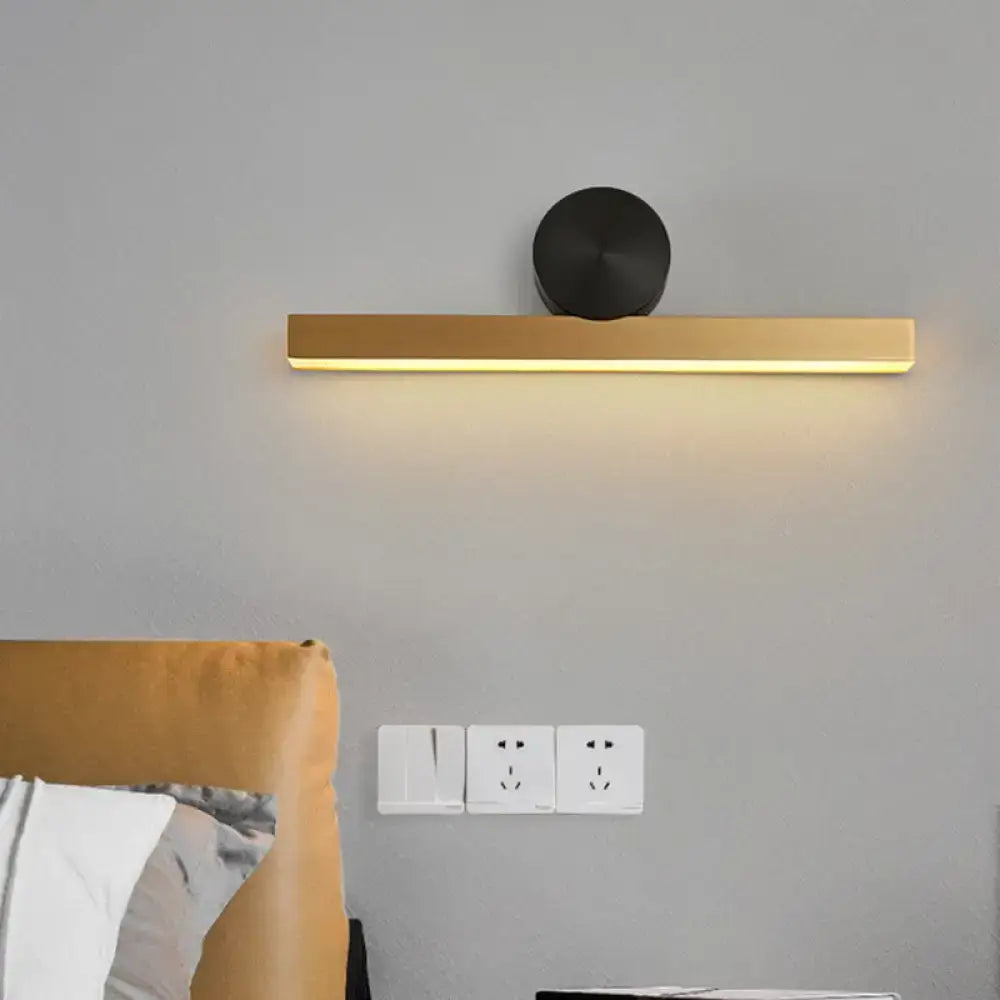 Modern gold and black wall sconce with sleek rectangular design and black circular accent for living room fixture width