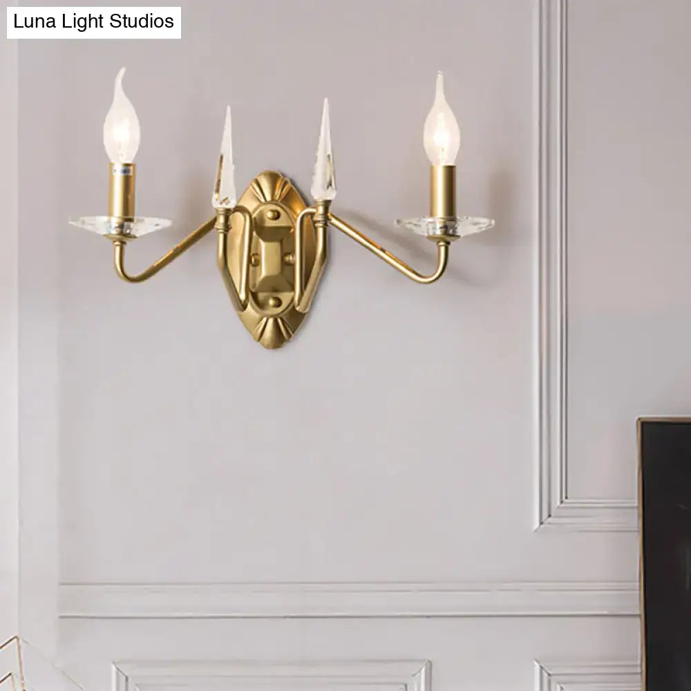 Brass-finished iron candle wall light with three candle-style bulbs and crystal accents for living room decor