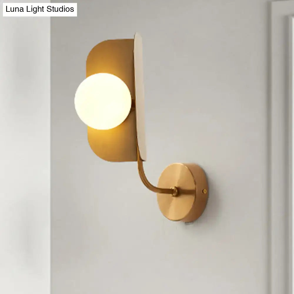 Modern gold sphere metal wall light featuring curved metal arms and a frosted glass bulb for bedroom use