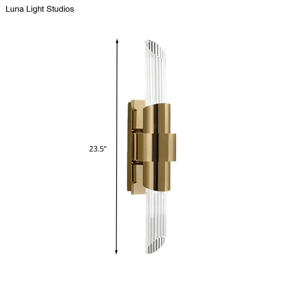 Modern gold wall lamp with vertical glass rods and geometric metal frame featuring a prismatic crystal shade for bedroom