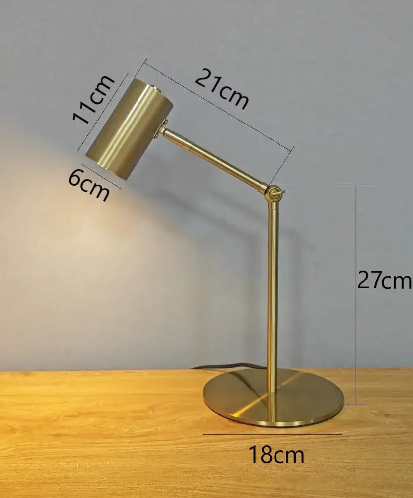 Modern nordic brass-finished golden table lamp with adjustable cylindrical head and circular base for decorbites golden table decor