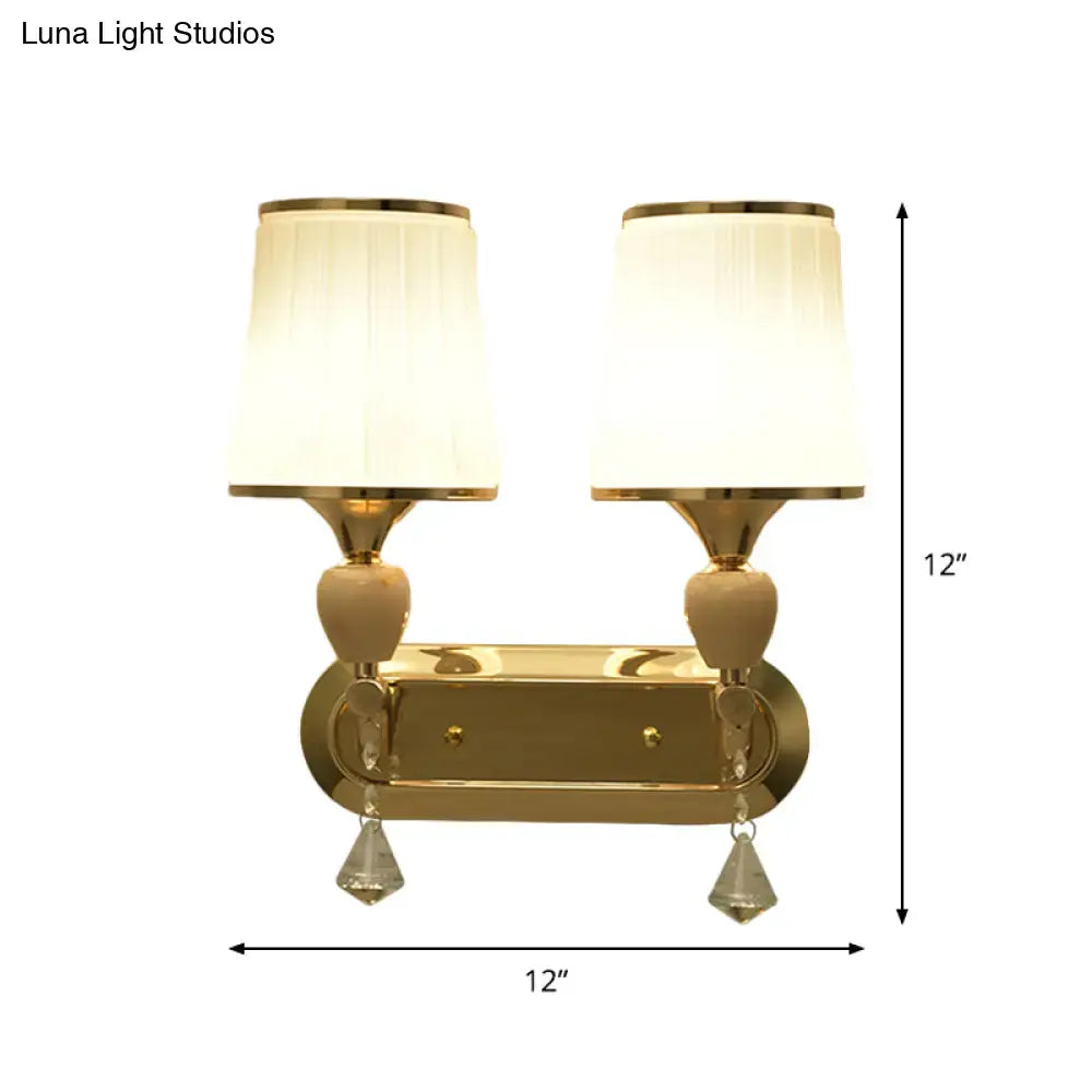Modernist gold crystal wall sconce with two cream pleated shades and teardrop pendants for living room use