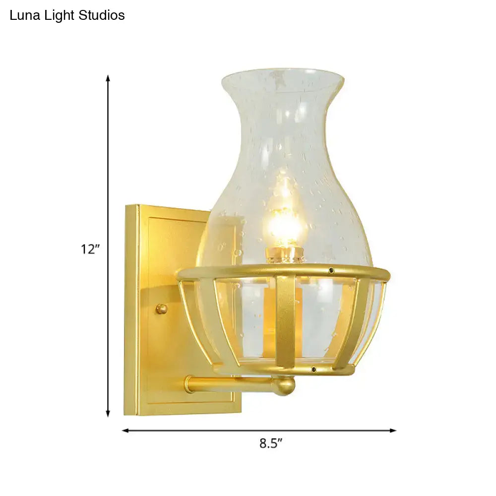 Postmodern gold wall lamp with clear glass shade and metal frame featuring brass cage detailing for living room use