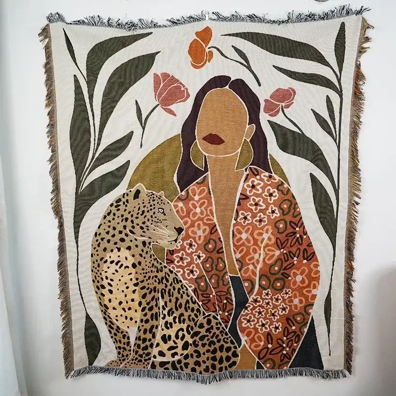 Beige woven ethnic tapestry sofa blanket featuring a woman in an orange floral jacket beside a leopard with floral motifs
