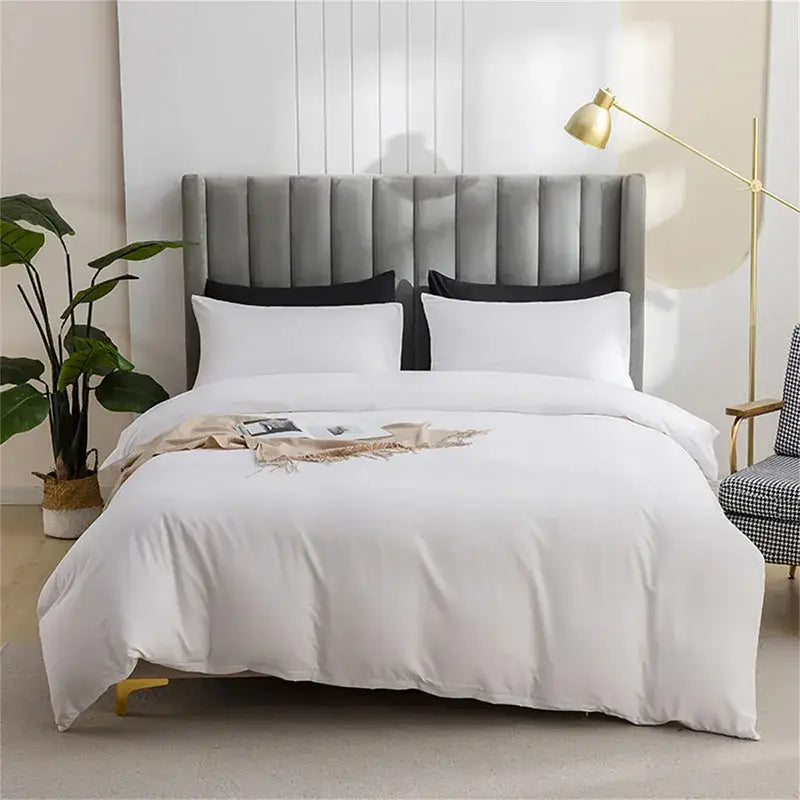 Gray tufted velvet headboard with black pillows and white bedding complementing quilted tan duvet cover set for soft bedding
