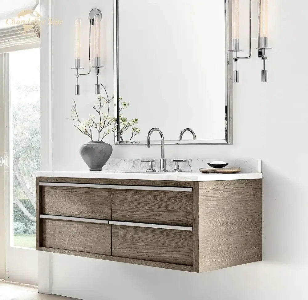 Modern floating bathroom vanity with gray wood finish and silver drawer pulls paired with decorbites glass double sconce wall light