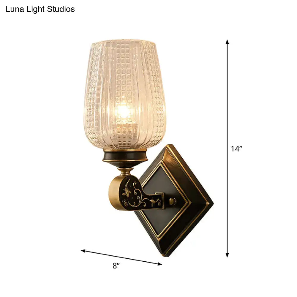 Vintage brass sconce with an antique brass finish and textured amber-tinted clear textured glass shade for living room lighting