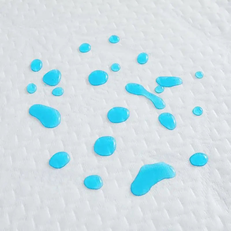 Bright blue liquid droplets on white bamboo jacquard waterproof fitted mattress cover showing absorbent texture