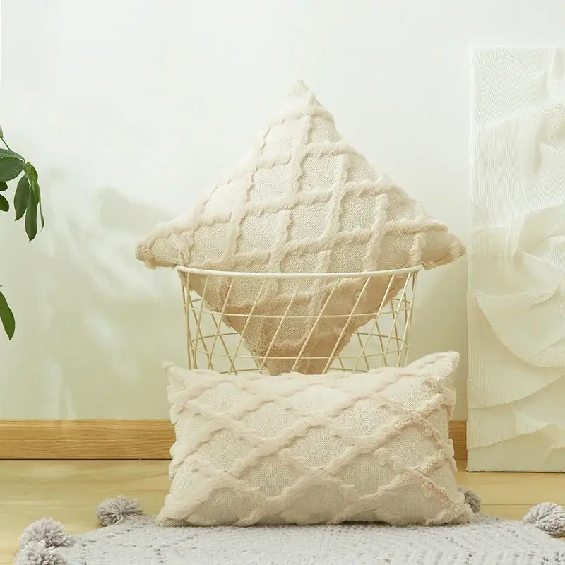 Cream-colored textured cushion cover with embroidered diamond knit design and soft fringe edges for living room decor
