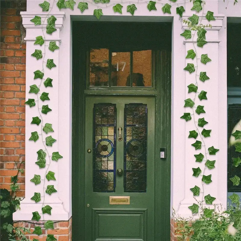 Deep green wooden door with stained glass panels and brass hardware featured with decorbites 12pcs ivy green garland string