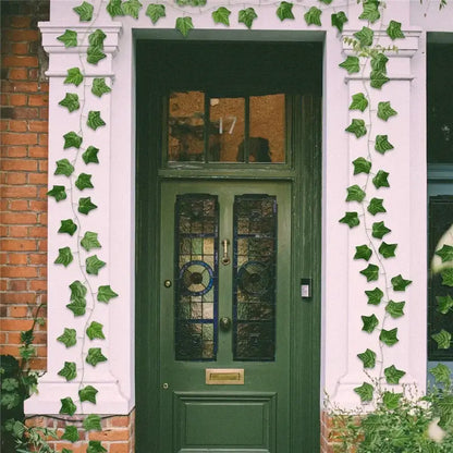 Deep green wooden door with stained glass panels and brass hardware featured with decorbites 12pcs ivy green garland string