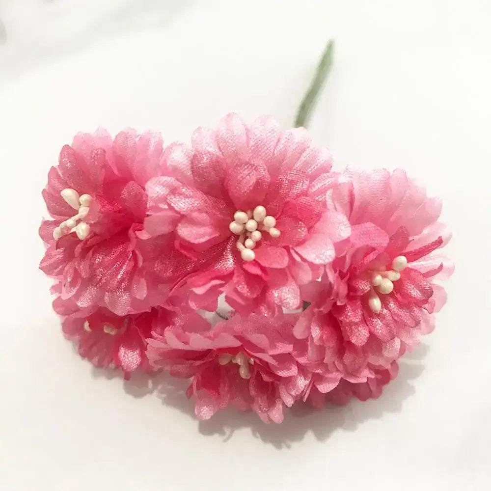 A cluster of delicate pink paper flowers with tiny white bead centers from a 200pcs mixed rose red stamen bundle