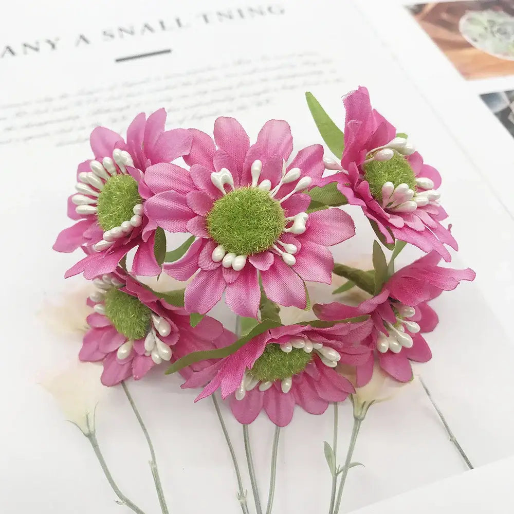 A cluster of artificial pink daisies with green centers and white beads in a 200pcs mixed rose red stamen bundle for diy decor