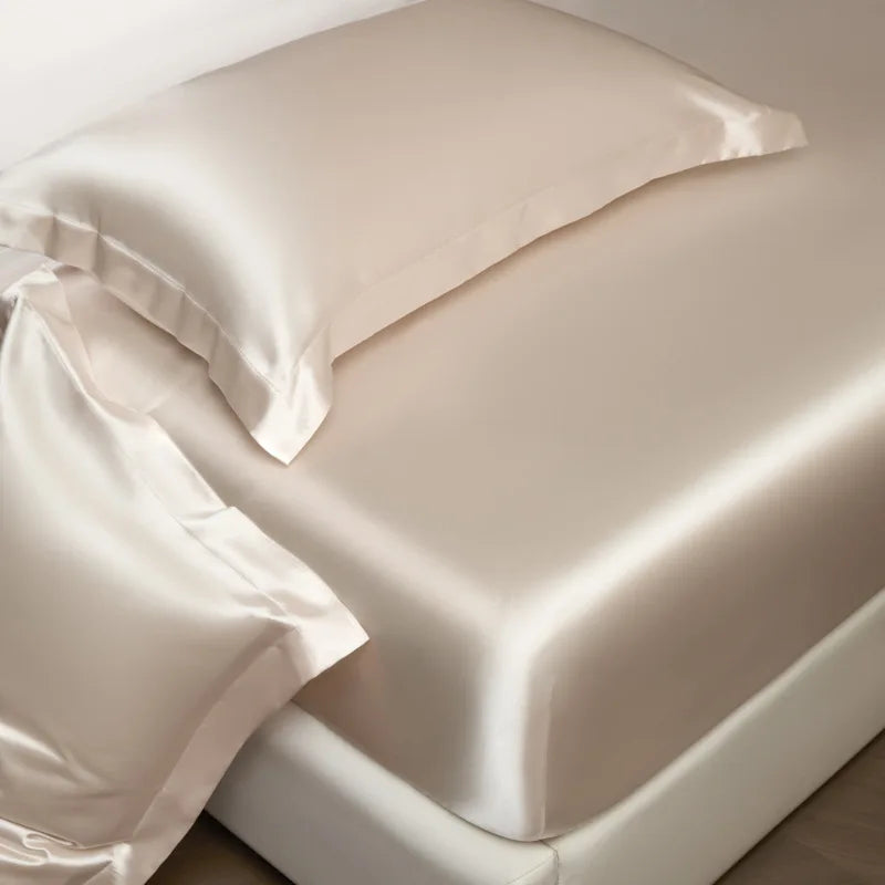 Cream-colored satin pillowcase with smooth glossy finish and stitched edges in high end mulberry silk sheet set