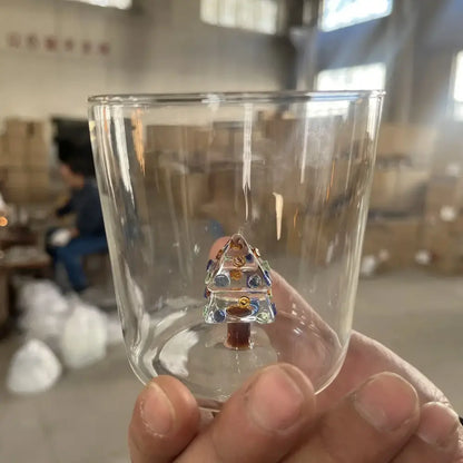 A clear glass 300ml 3d christmas tree wine glass featuring a detailed blue and gold christmas tree ornament inside