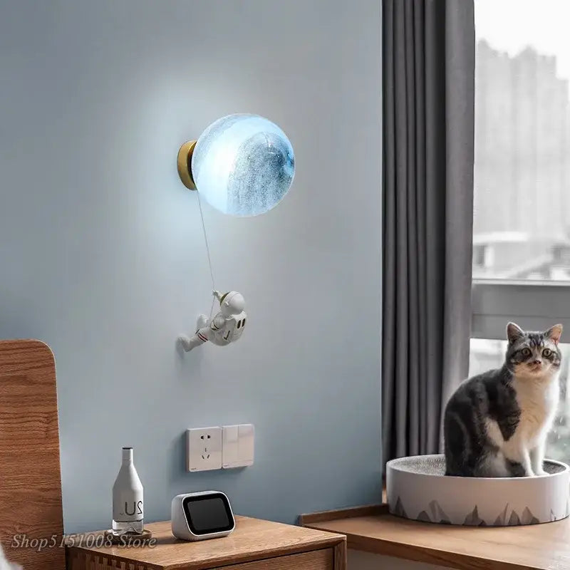 Blue translucent spherical wall lamp with white astronaut figurine hanging below for kids bedroom decorbites astronaut moon wall